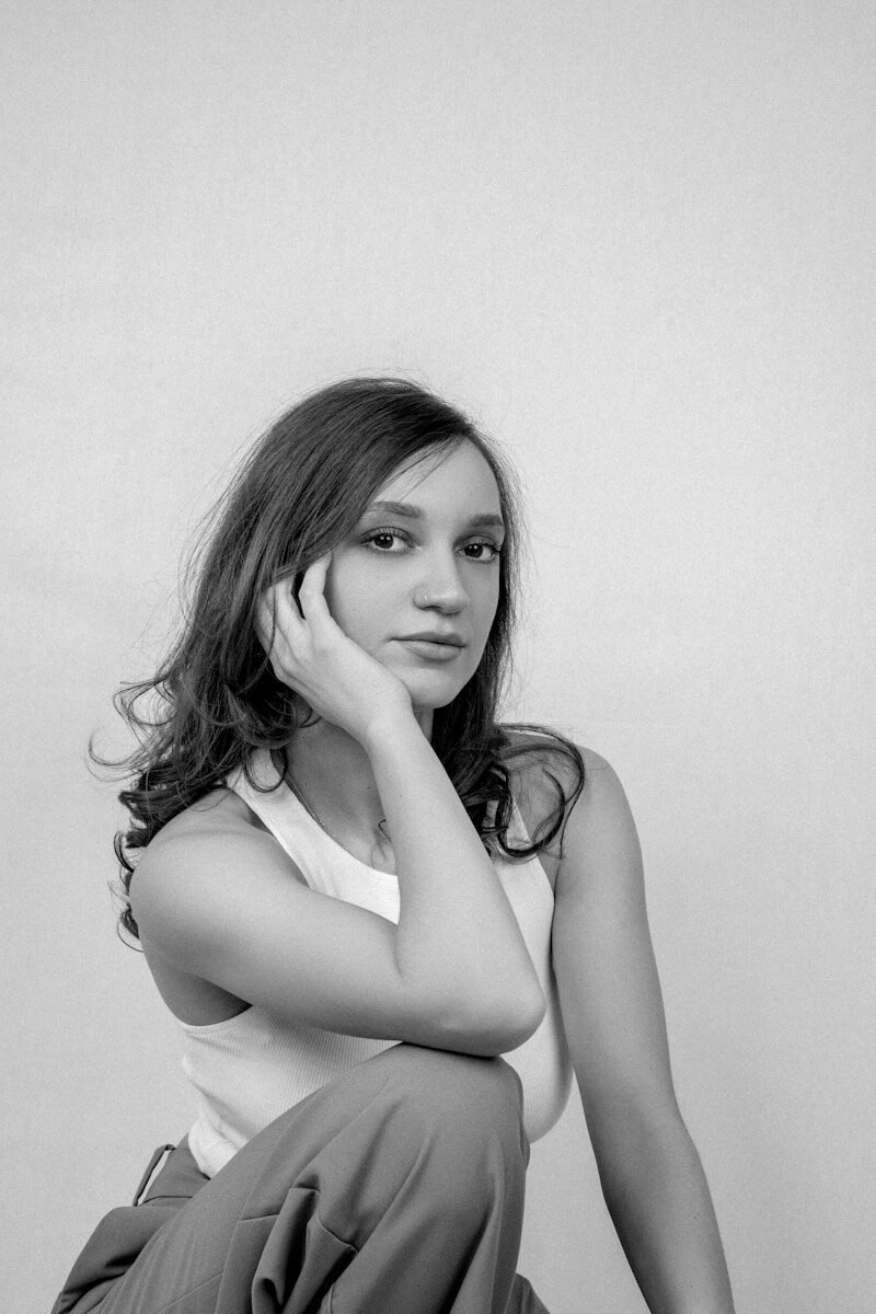 A young woman rests her chin on her hand