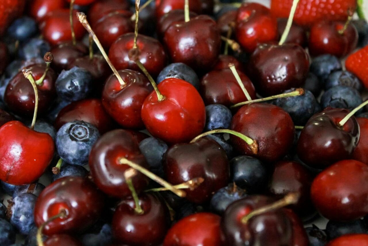 Vibrant mix of cherries, blueberries, and strawberries in a close-up shot.