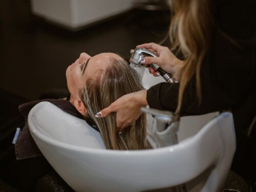 a woman getting her hair cut by a hair stylist