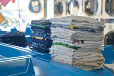 a stack of folded shirts sitting on top of a blue table