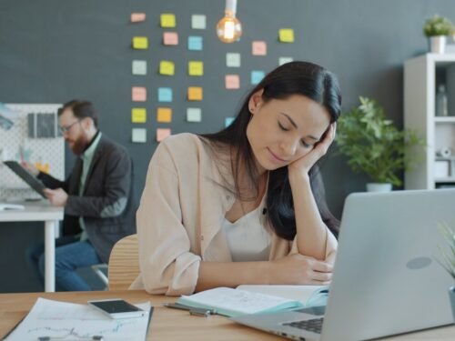 Woman resting head on hand at desk