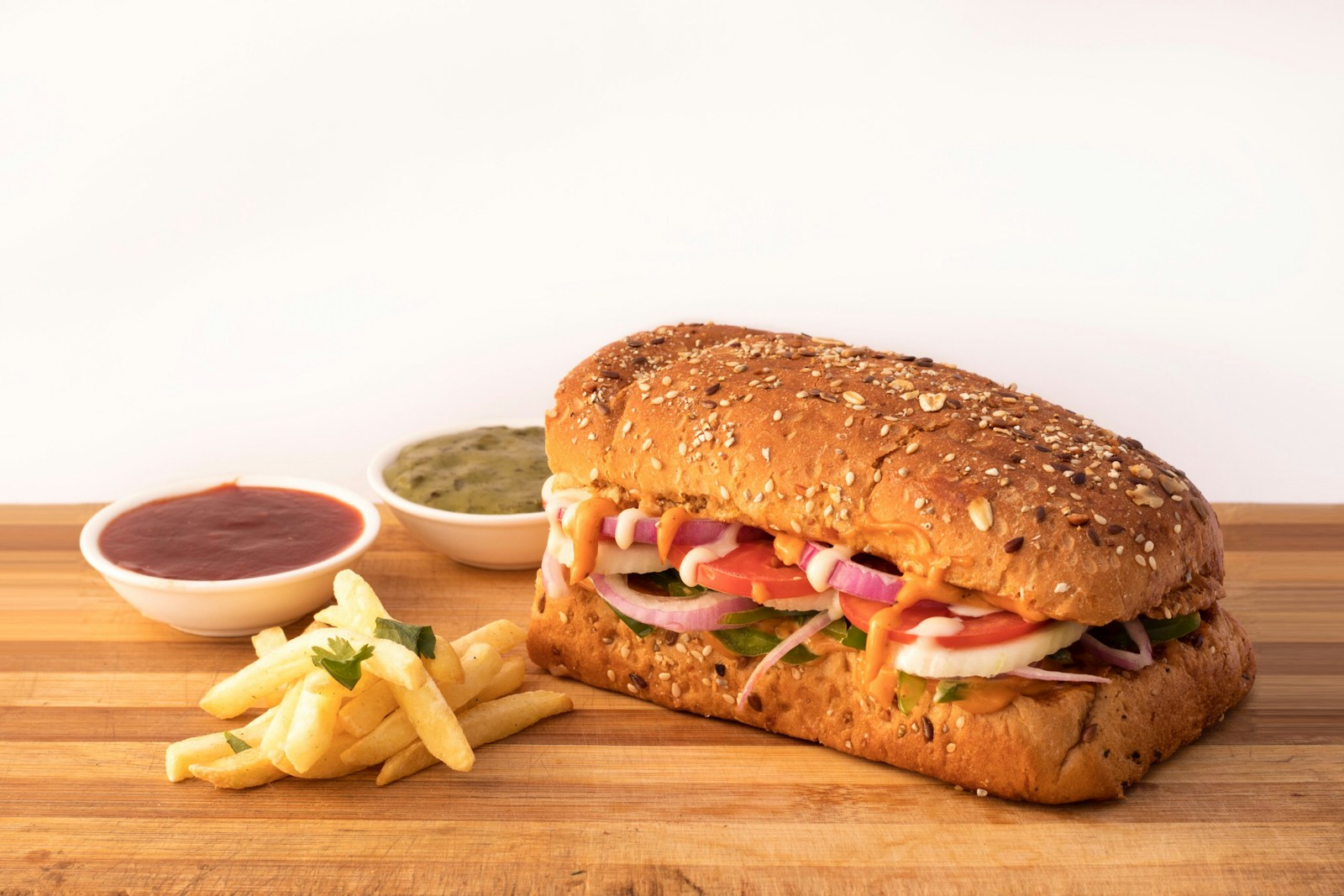 burger sandwich and potato fries on brown wooden surface