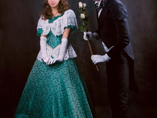 man in black suit jacket beside woman in green dress