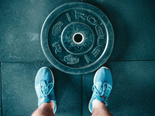 person standing beside black weights