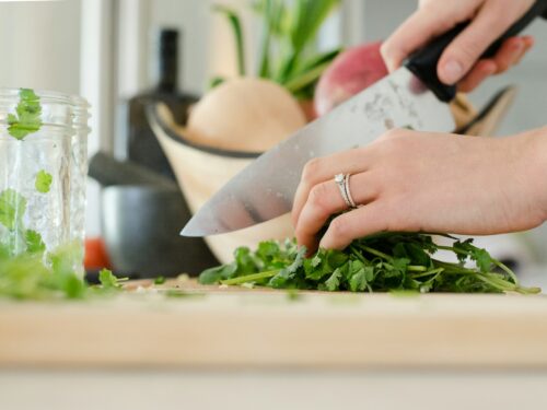 person cutting vegetables with knife