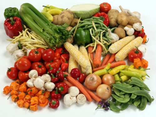 a pile of different types of vegetables on a white surface