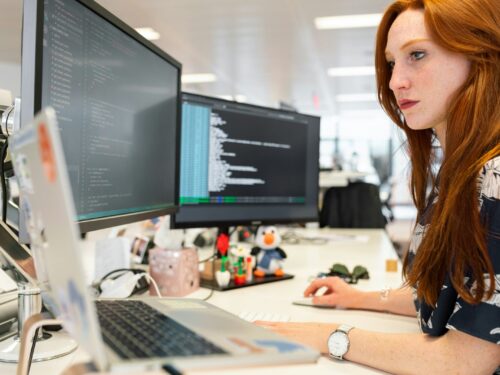 woman in green shirt sitting in front of computer