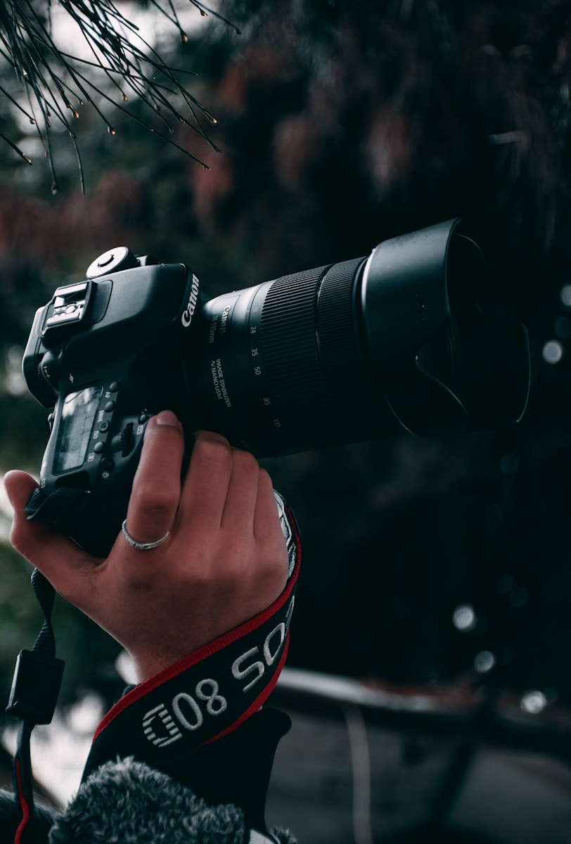 person holding black canon dslr camera