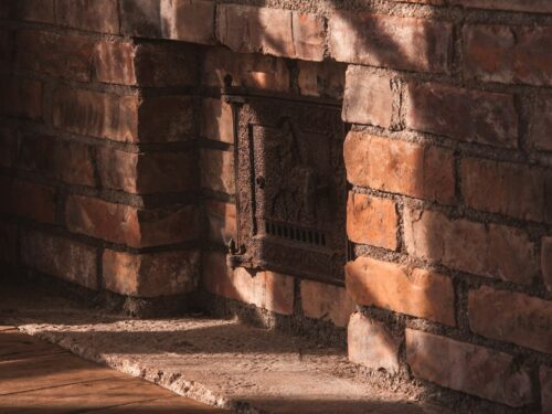 brown brick wall with black metal door