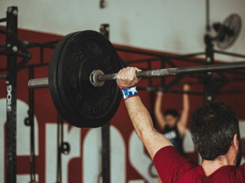 man carrying barbell at the gym