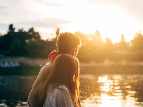 couple walking on lake side watching sunset close-up photo