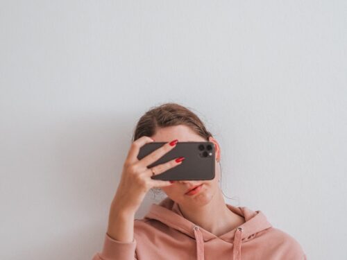 woman in pink hoodie wearing black sunglasses