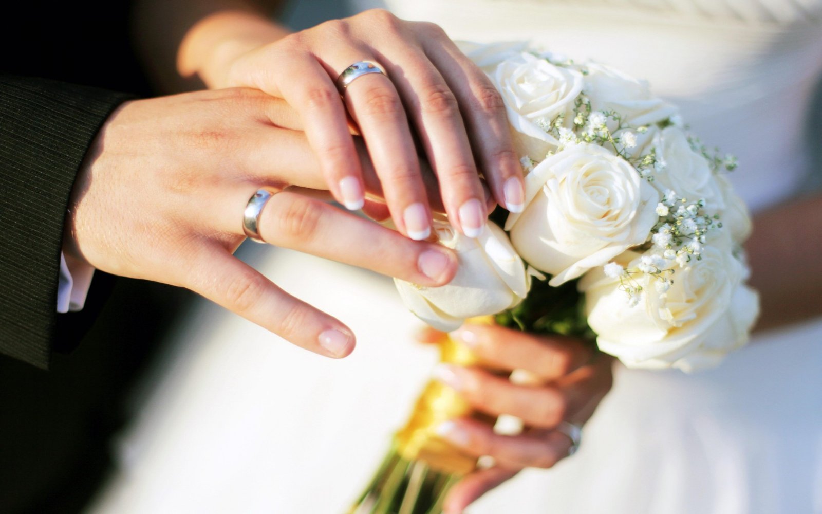 Hands wedding rings bouquet roses.jpg