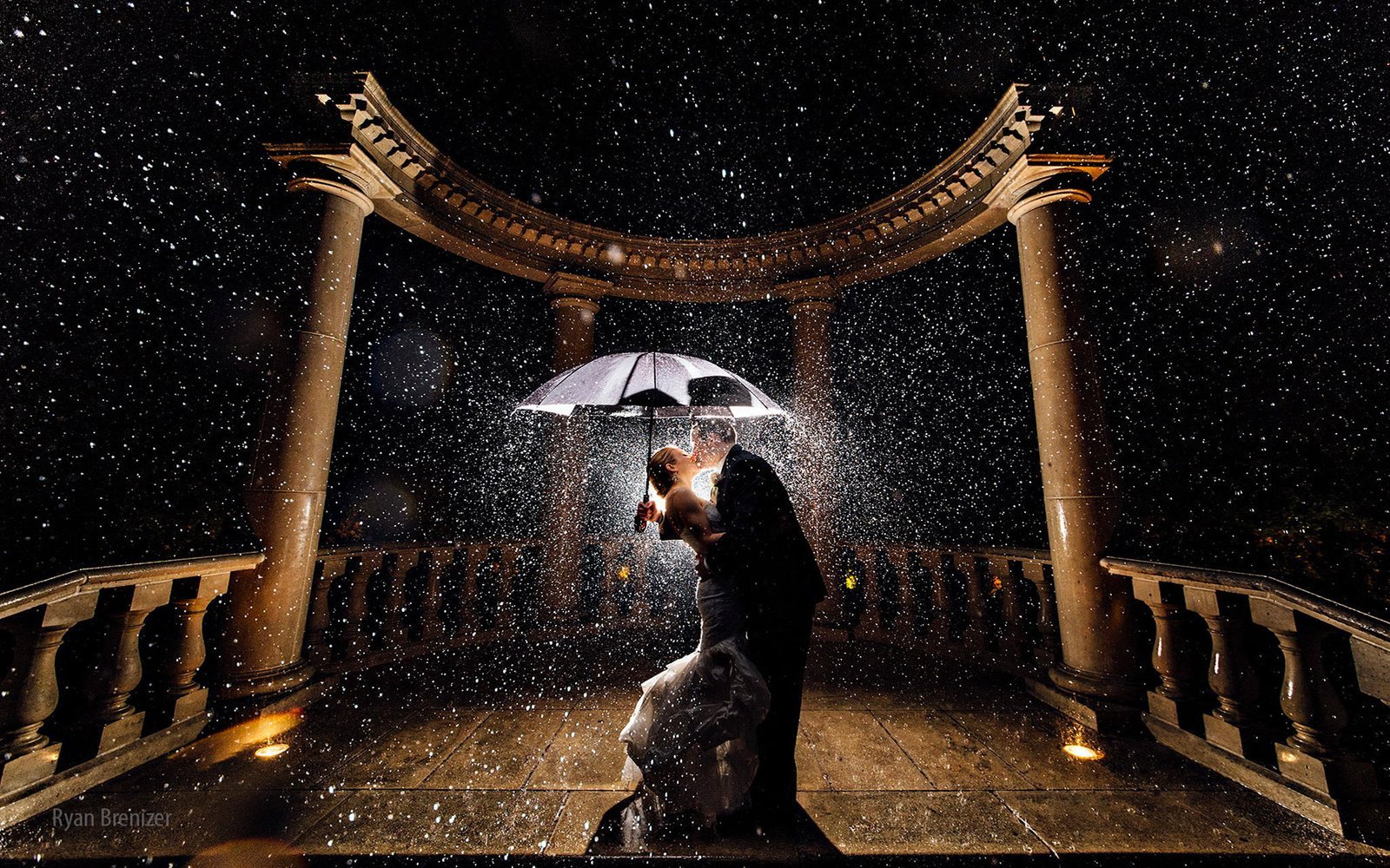 Newly Married couple kissing in rain.jpg