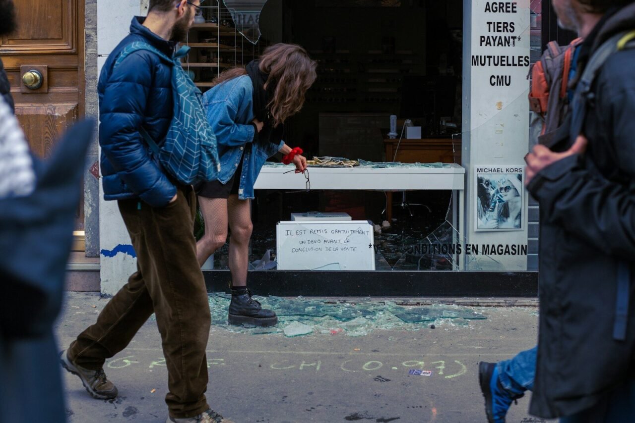 a man and a woman walking past a broken window