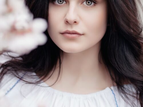 woman standing near white petaled flower