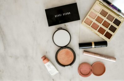 photo of assorted makeup products on gray surface