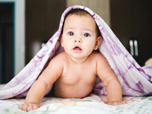 baby under purple blanket