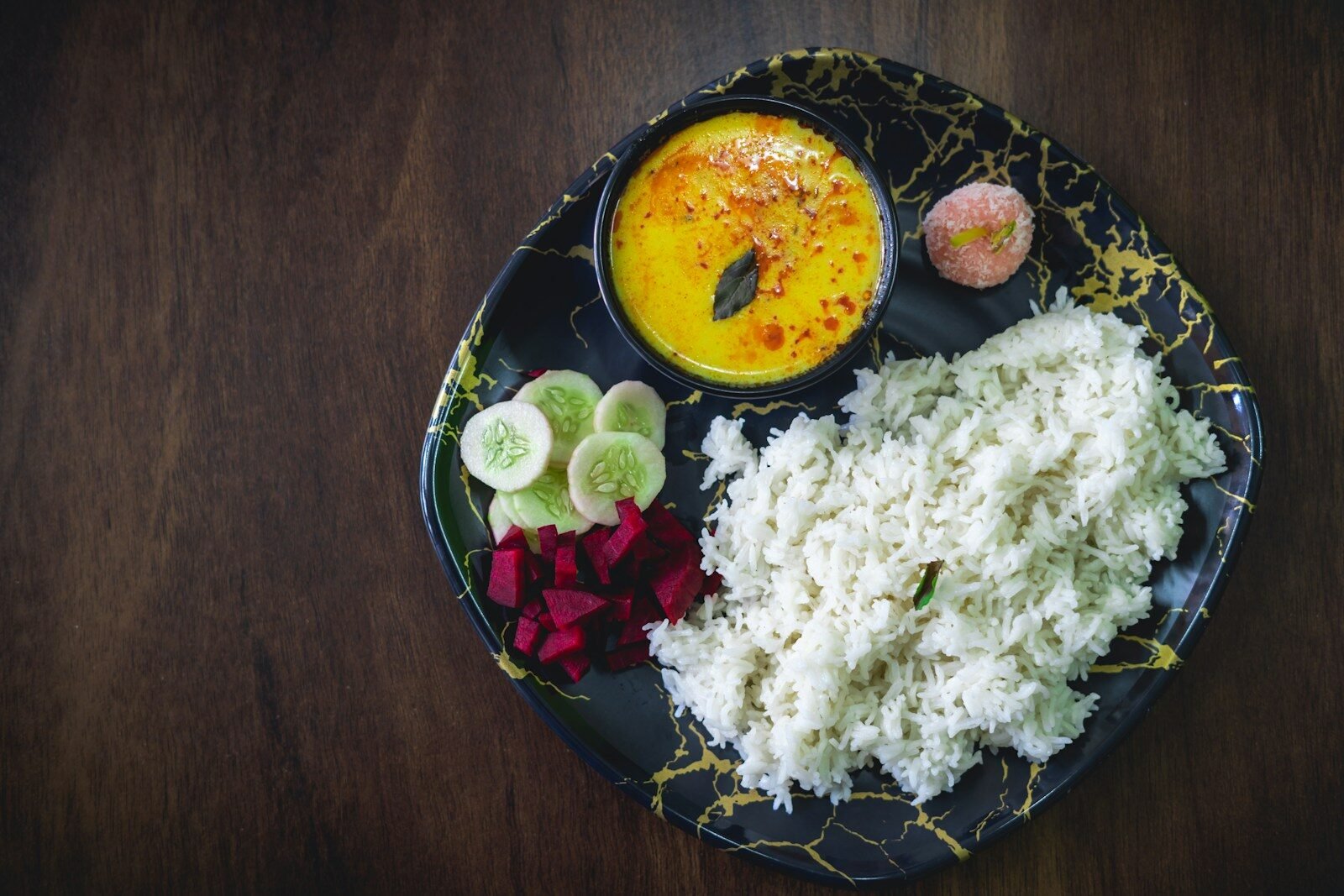 A black plate topped with different types of food