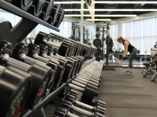 woman standing surrounded by exercise equipment