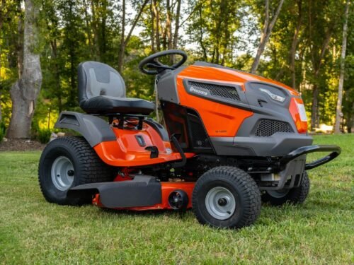 orange and black ride on lawn mower on green grass field