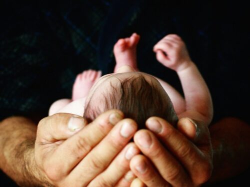 person holding babys hand