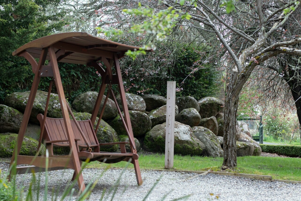 a wooden swing set in a park setting