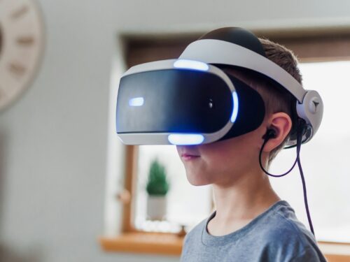 boy wearing black and white VR headset