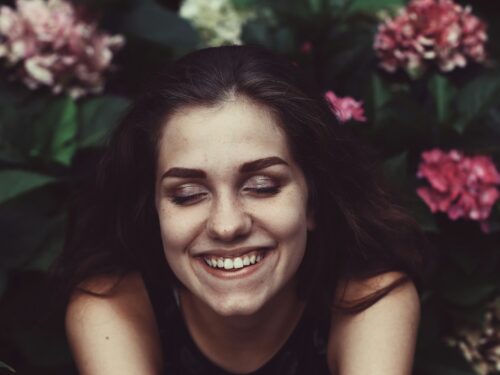 woman smiling face surrounded by flowers