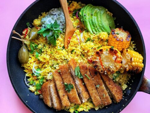 fried meat with green vegetable on black plate