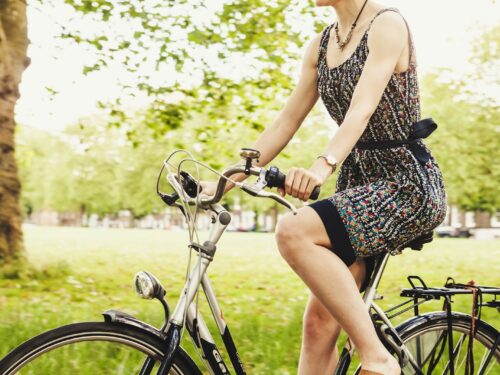 woman riding bicycle near grass