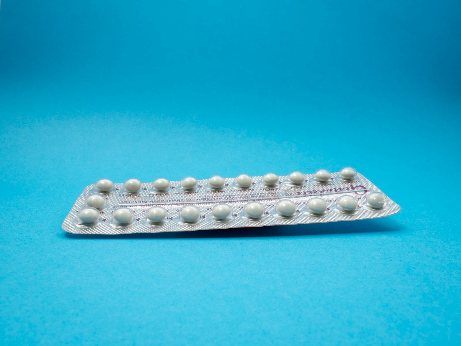 oral contraceptive pill on blue panel