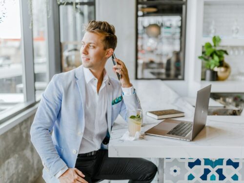 man sitting beside white wooden table