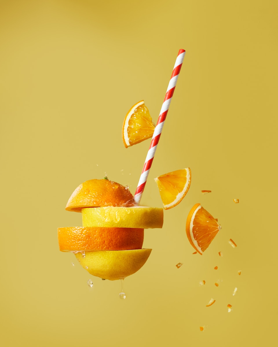 sliced orange fruit with straw