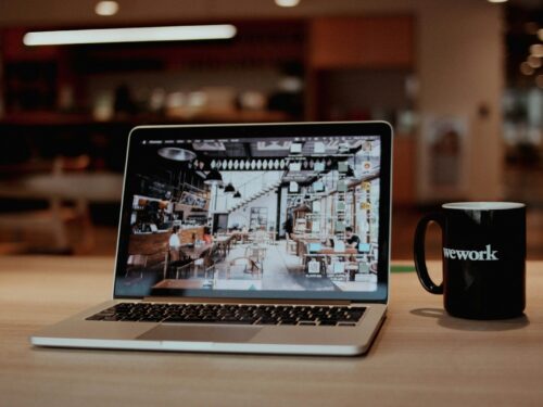 a laptop with a coffee cup