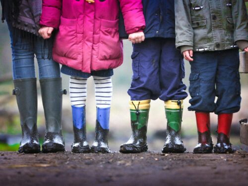 four children standing on dirt during daytime