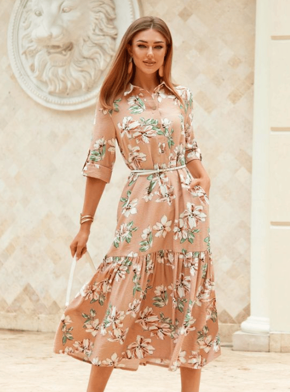 Moteris suknele su gėlių raštu.