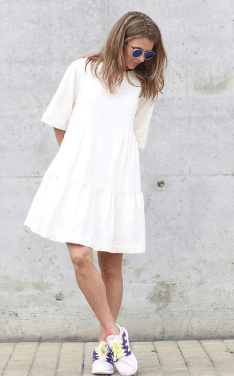 Moteris lakoniškų siluetų suknele.