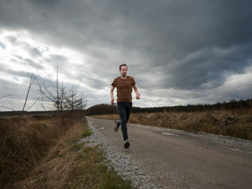 man running at the road during daytime