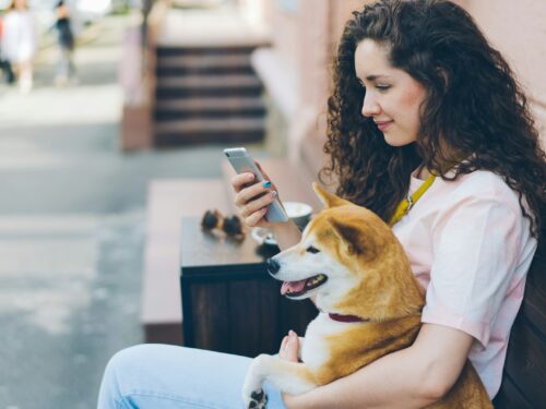 a woman sitting on a bench holding a dog