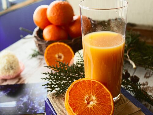 a glass of orange juice sitting on top of a book