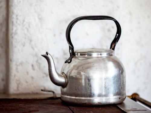 stainless steel kettle on brown wooden table