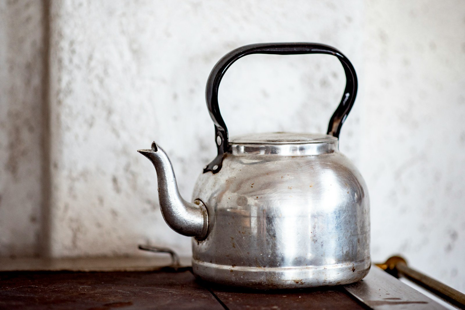 stainless steel kettle on brown wooden table