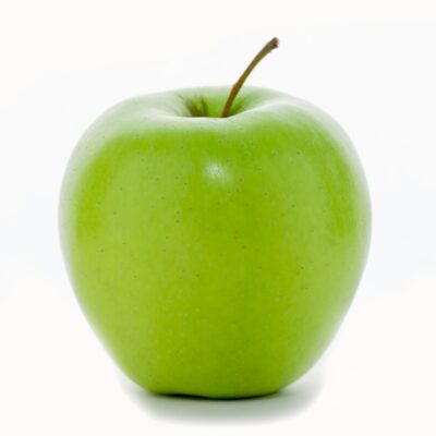 a green apple sitting on top of a white table