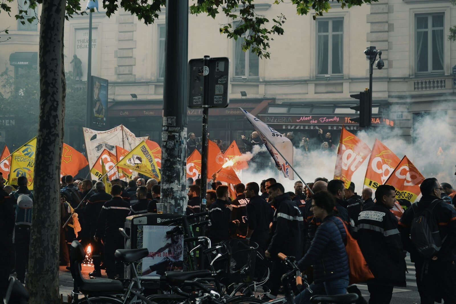 people waving flags beside building during daytime