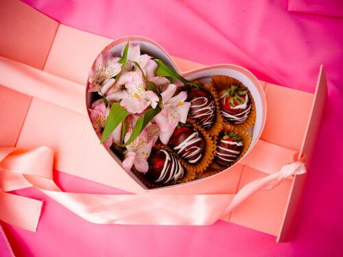 a heart shaped box filled with chocolate covered strawberries