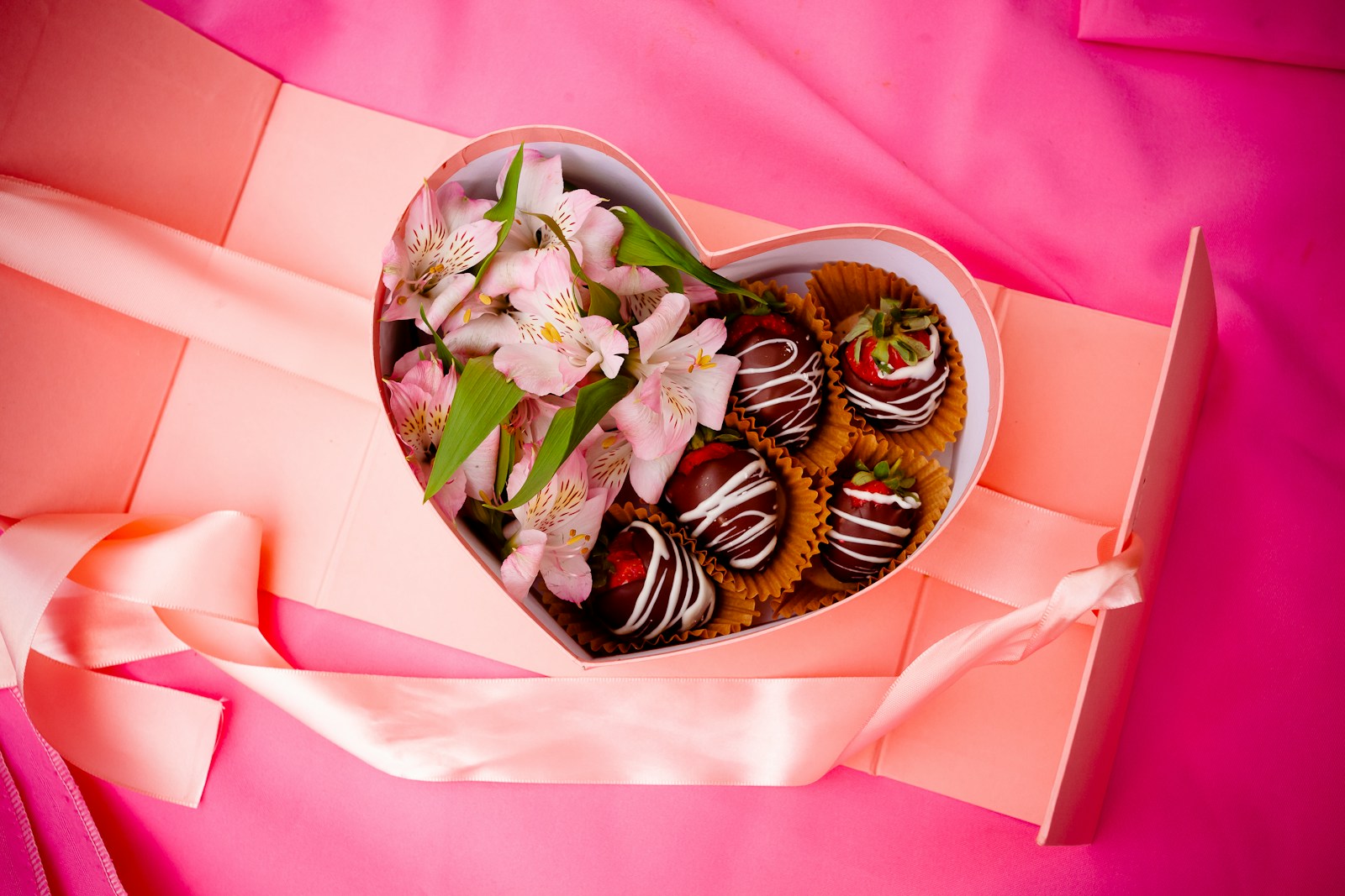 a heart shaped box filled with chocolate covered strawberries