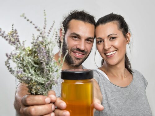 man and woman holding plants