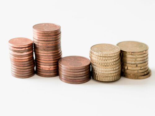 stacked round gold-colored coins on white surface