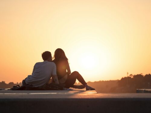 couple sitting near trees during golden hour